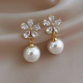 Pearl earrings with gold accents on a soft fabric background