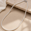 Pearl necklace on a beige stone surface