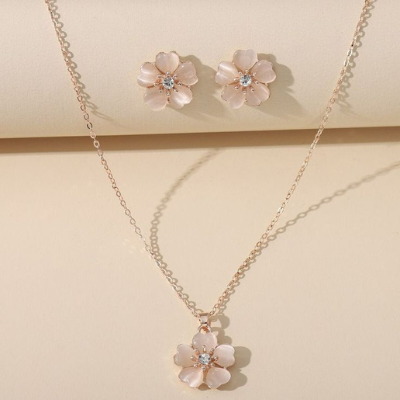Flower-shaped necklace and earrings on a beige background
